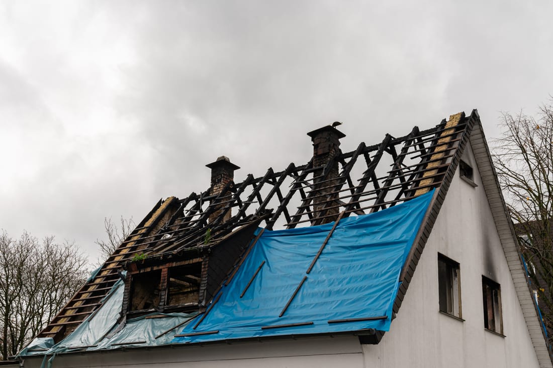 Storm-damaged roof under an emergency tarp in North Carolina